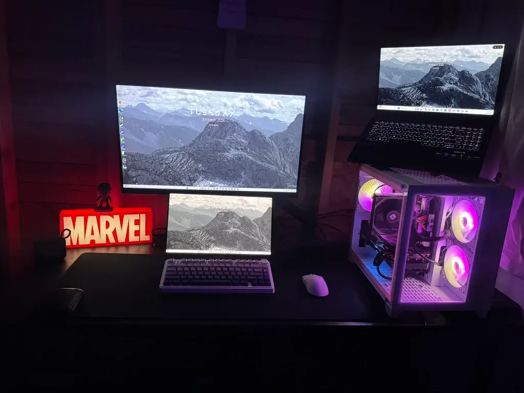 My desk setup with multiple displays and the illuminated desktop PC that runs my Plex server